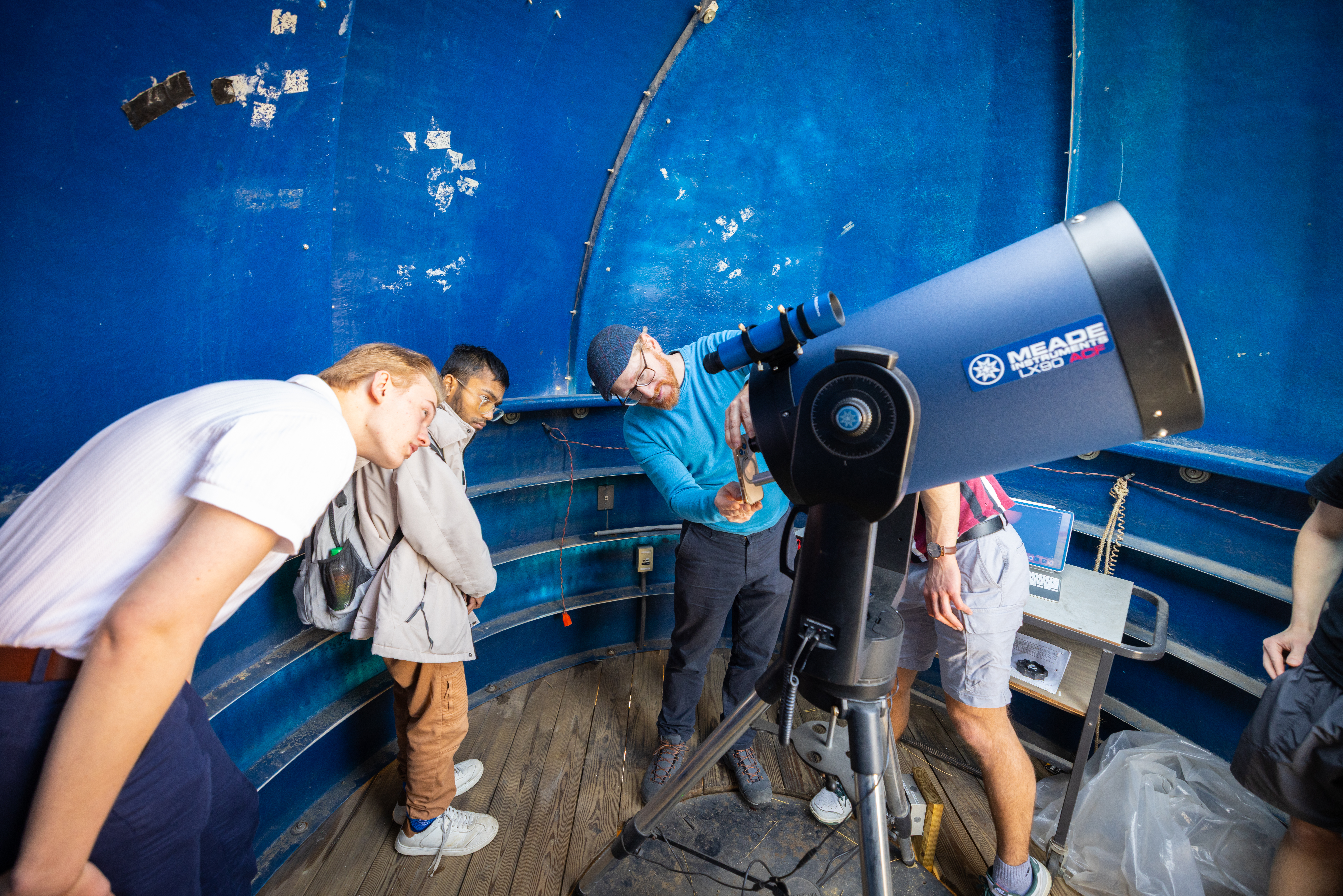 Tim Thomay instructs students on the telescope on the roof of Fronczak Hall